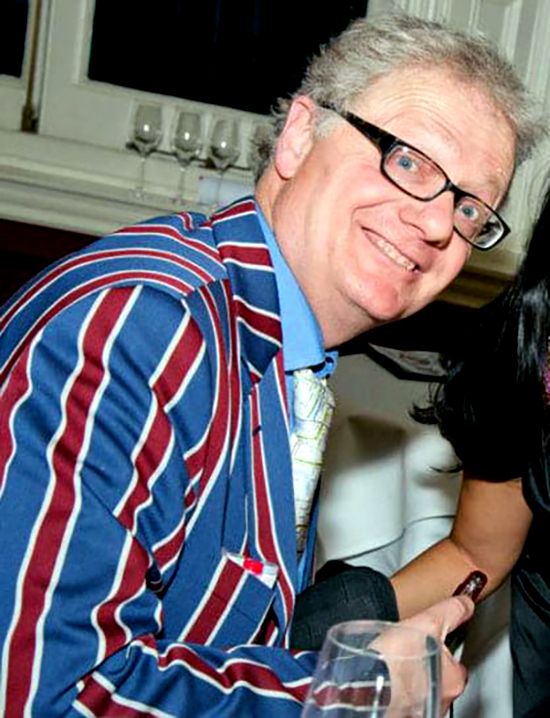 Caricaturist Simon Ellinas Caricaturist in Striped Blazer drawing caricatures in London